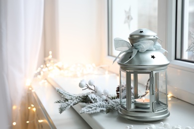 Beautiful Christmas lantern and other decorations on window sill