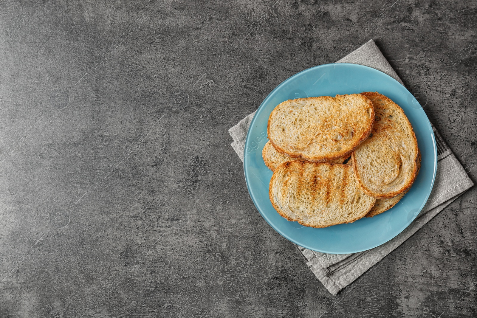 Photo of Plate with toasted bread on grey background, top view