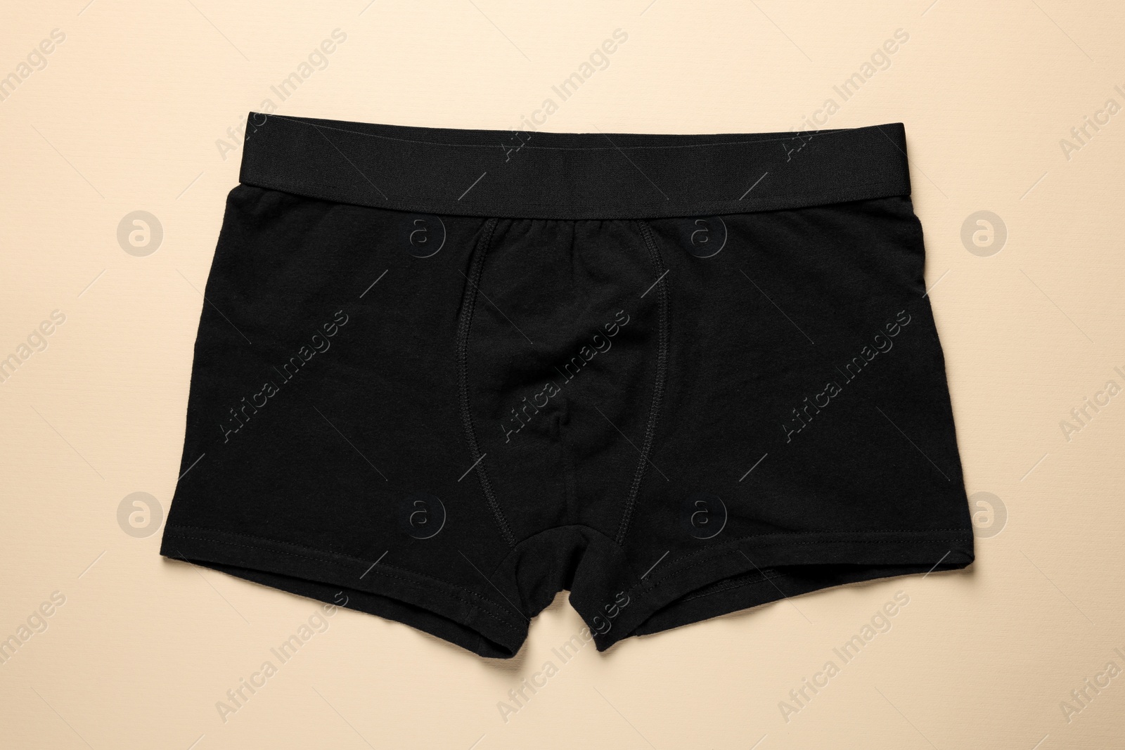 Photo of Comfortable black men's underwear on beige background, top view