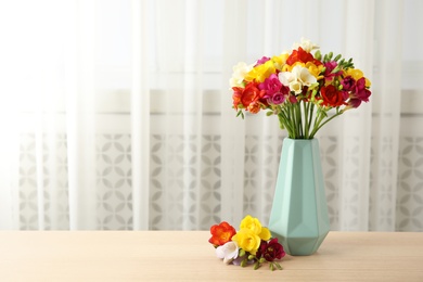 Photo of Vase with bouquet of spring freesia flowers on table in room