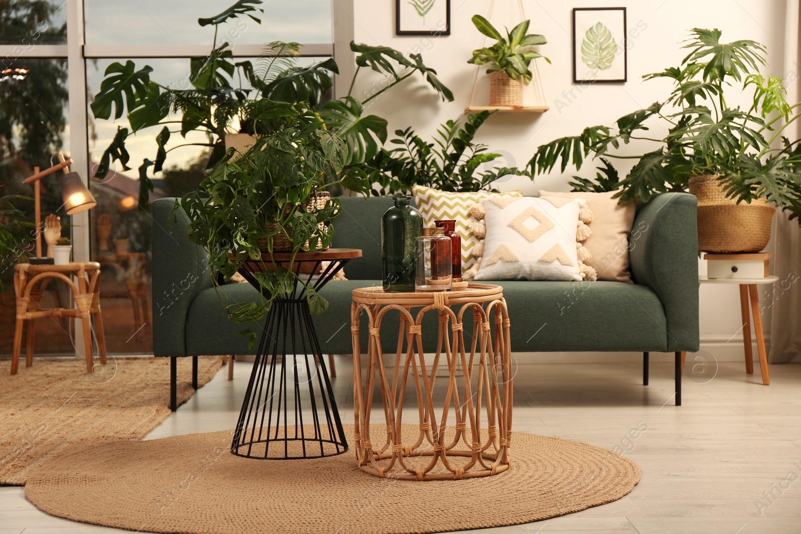 Photo of Stylish room interior with different houseplants and furniture near window