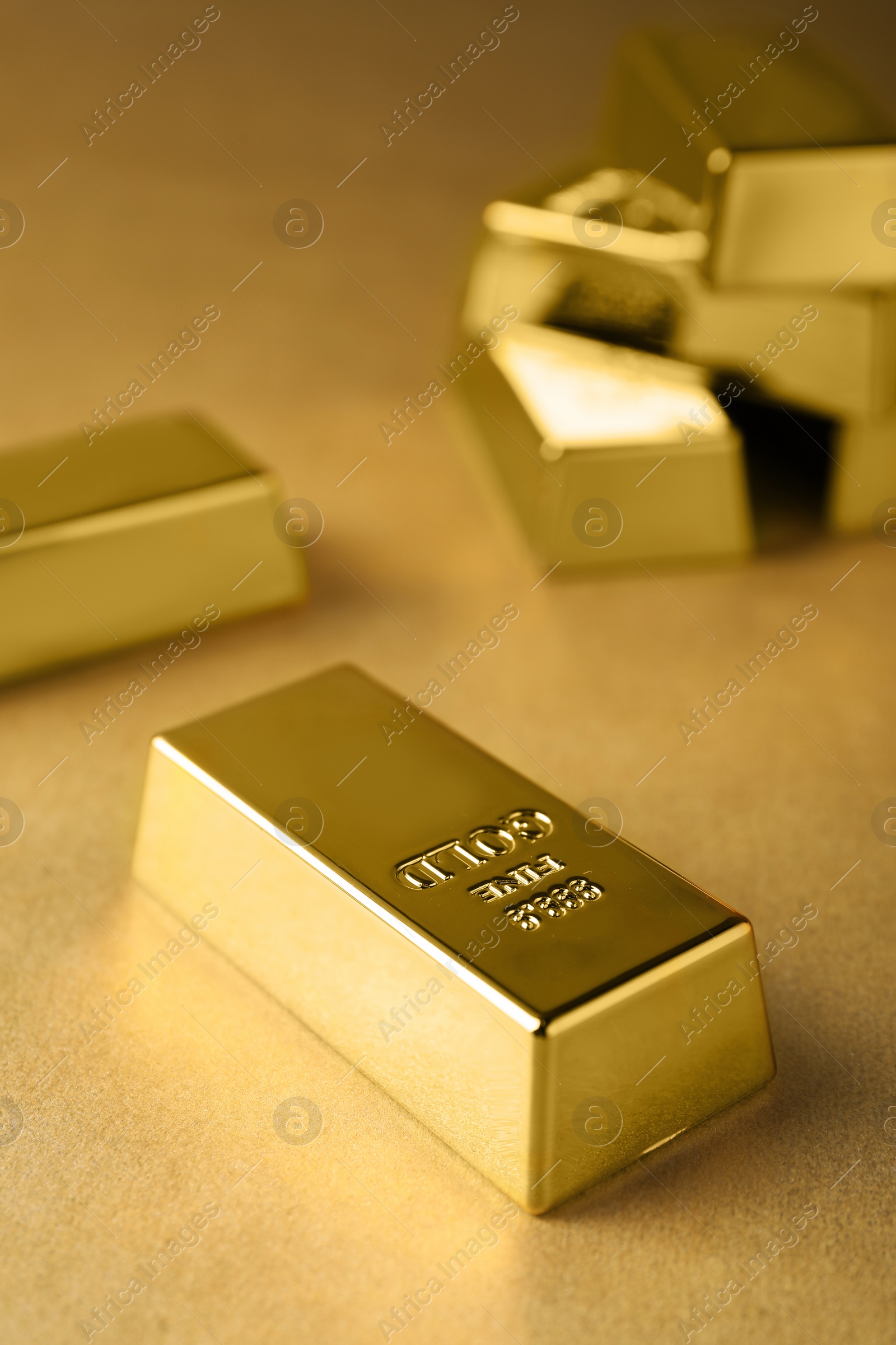 Photo of Many shiny gold bars on color background