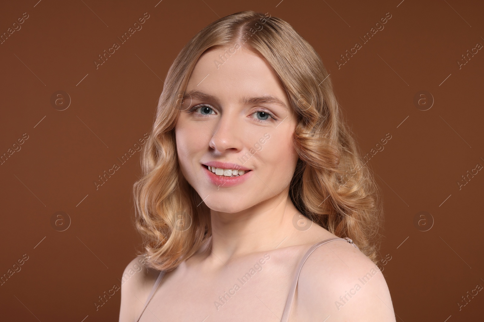 Photo of Portrait of beautiful woman with blonde hair on brown background