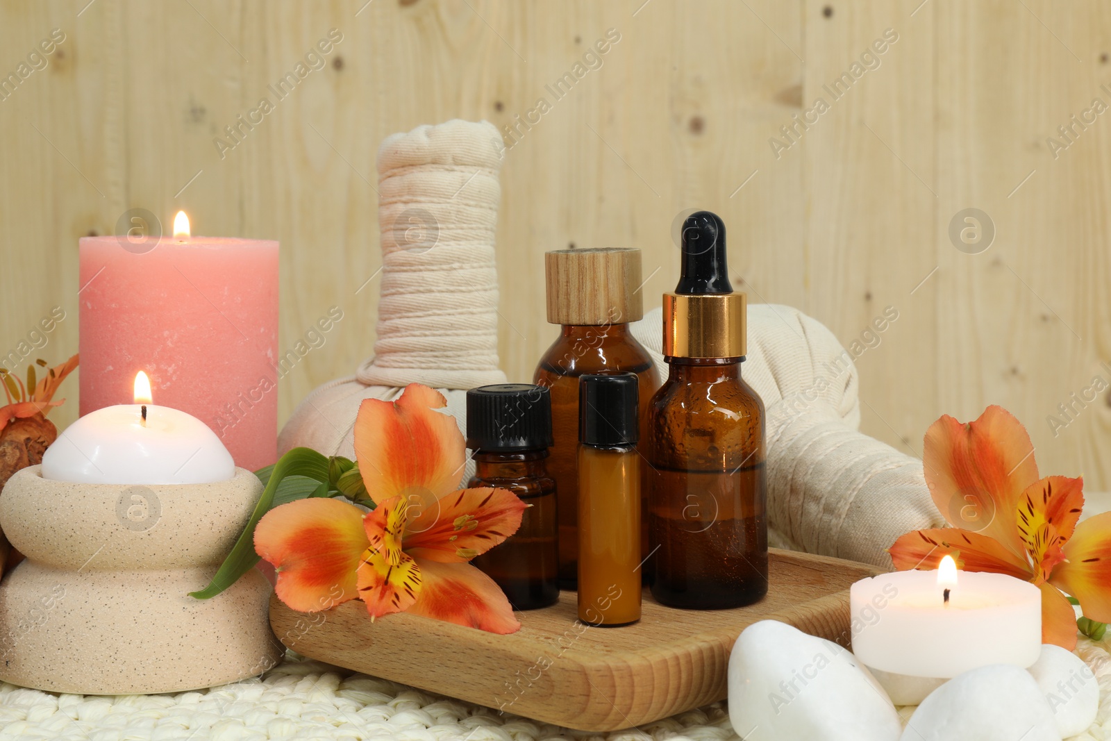 Photo of Different aromatherapy products and burning candles on table