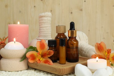 Photo of Different aromatherapy products and burning candles on table