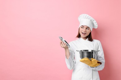 Professional chef with cooking pot on pink background. Space for text