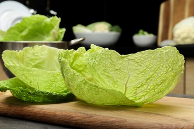 Photo of Fresh Savoy cabbage leaves on table in kitchen, closeup