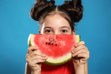 Photo of Cute little girl with watermelon on blue background, closeup