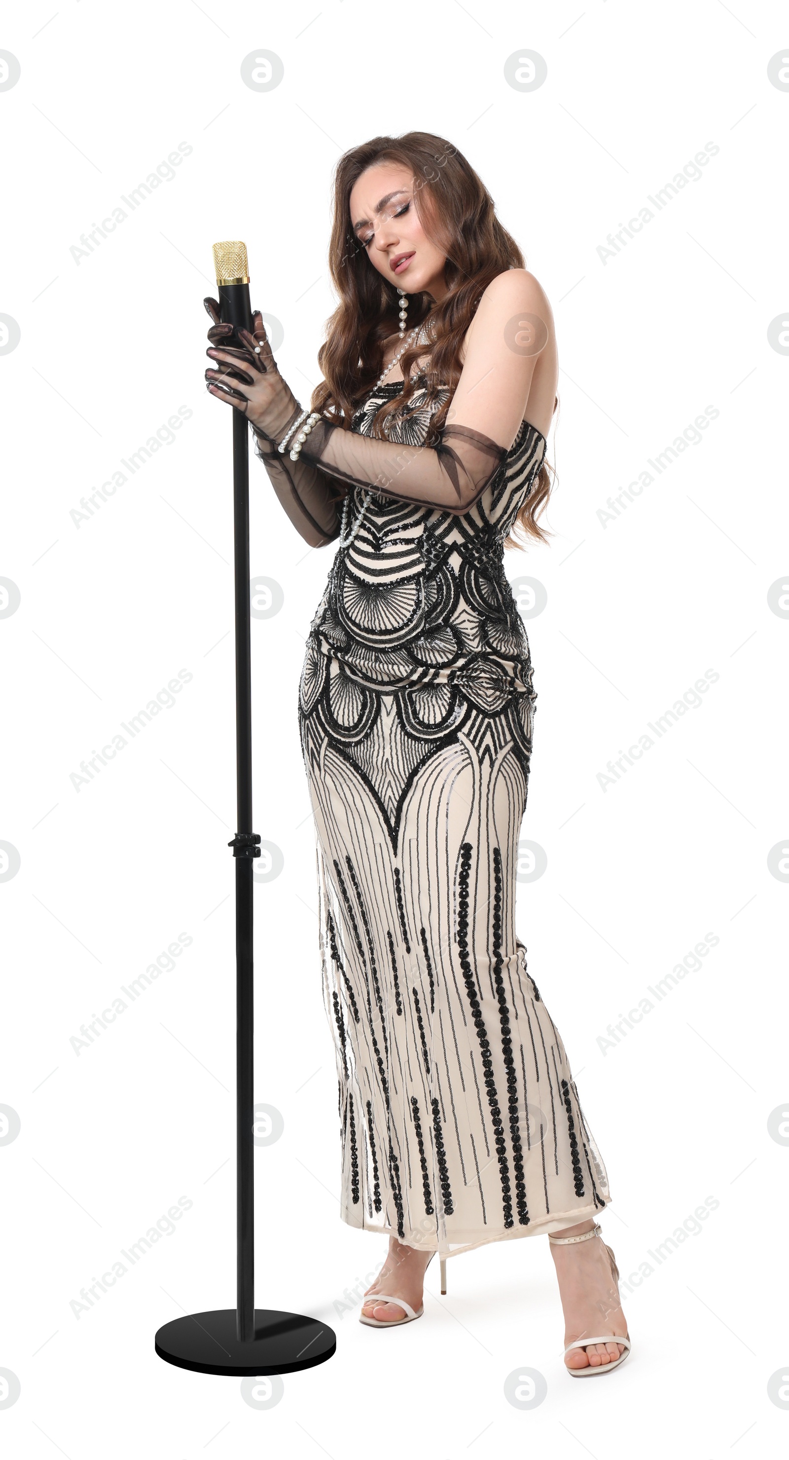 Photo of Beautiful young woman in stylish dress with microphone singing on white background