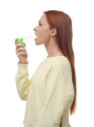 Young woman using throat spray on white background
