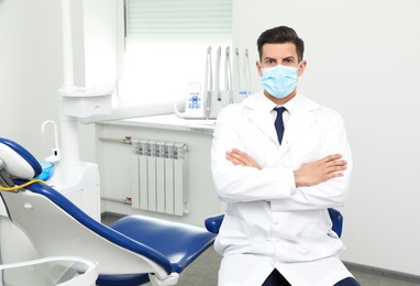 Photo of Portrait of professional male dentist in clinic. Space for text
