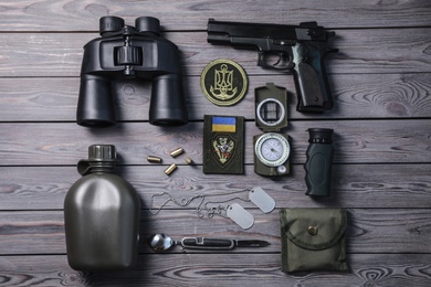 Photo of MYKOLAIV, UKRAINE - SEPTEMBER 19, 2020: Flat lay composition with Ukraine military equipment on grey wooden table