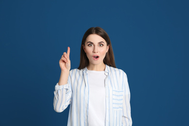 Portrait of emotional young woman on blue background