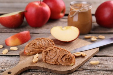 Photo of Fresh apples with peanut butter on wooden table