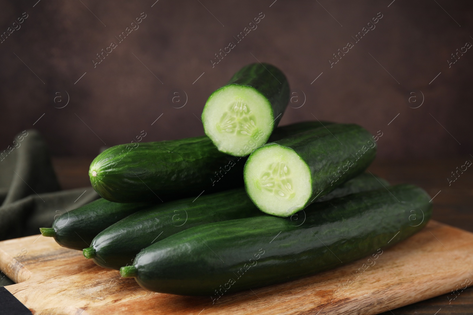 Photo of Many fresh cucumbers on wooden table, closeup