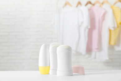 Photo of Different deodorants on white table in room. Space for text