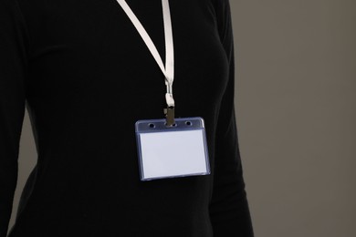 Photo of Woman with blank badge on grey background, closeup