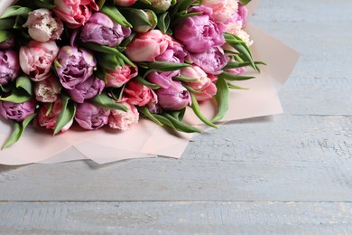 Photo of Bouquet of beautiful tulips on grey wooden table, closeup. Space for text