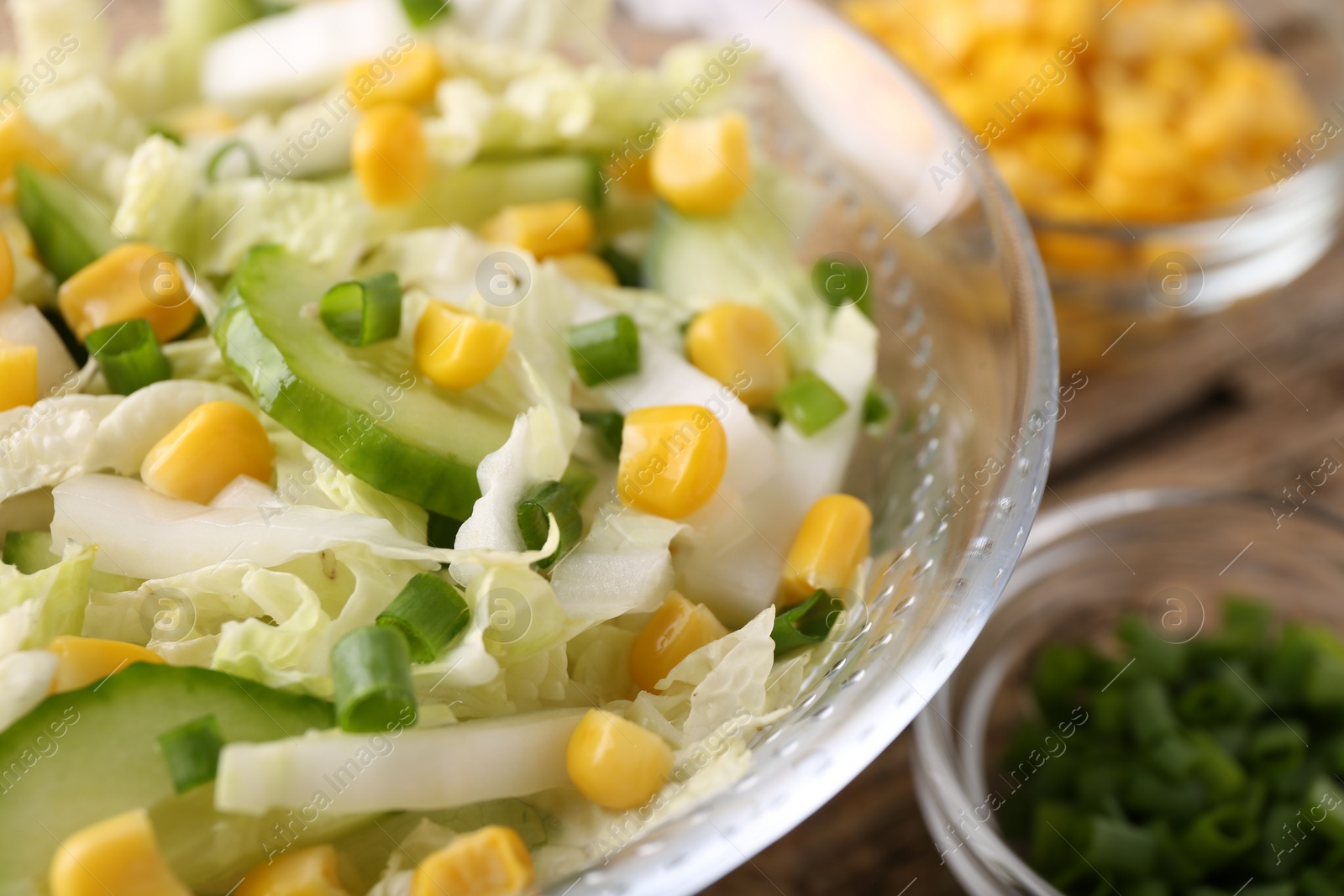 Photo of Tasty salad with Chinese cabbage, corn and cucumber in bowl on table, closeup