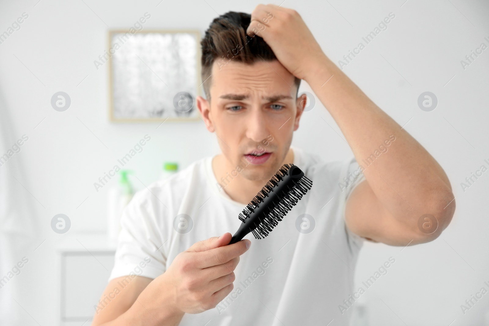 Photo of Young man with hair loss problem indoors