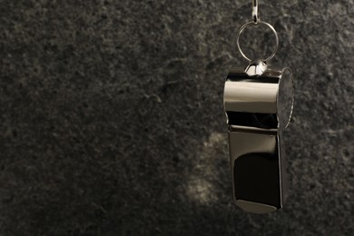 Referee equipment. Metal whistle on grey textured background, closeup and space for text