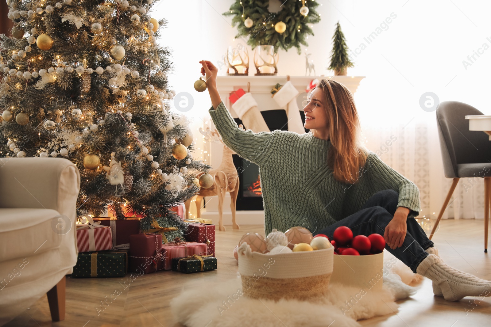 Photo of Beautiful woman decorating Christmas tree at home