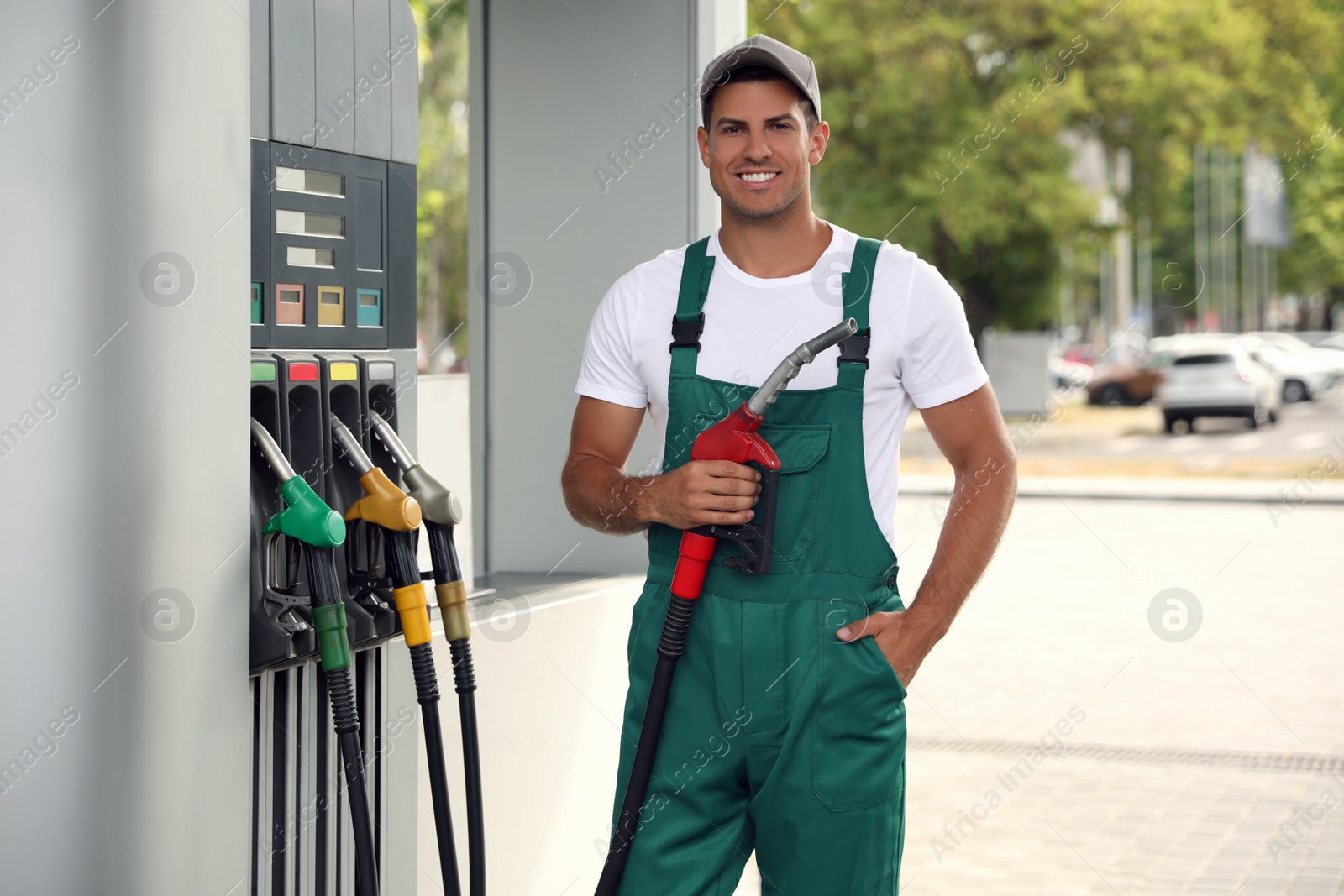 Photo of Worker with fuel pump nozzle at modern gas station