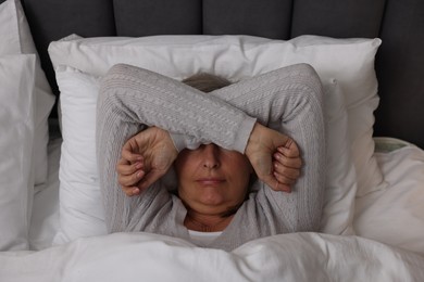 Photo of Menopause, sleep problems. Woman suffering from insomnia in bed, top view
