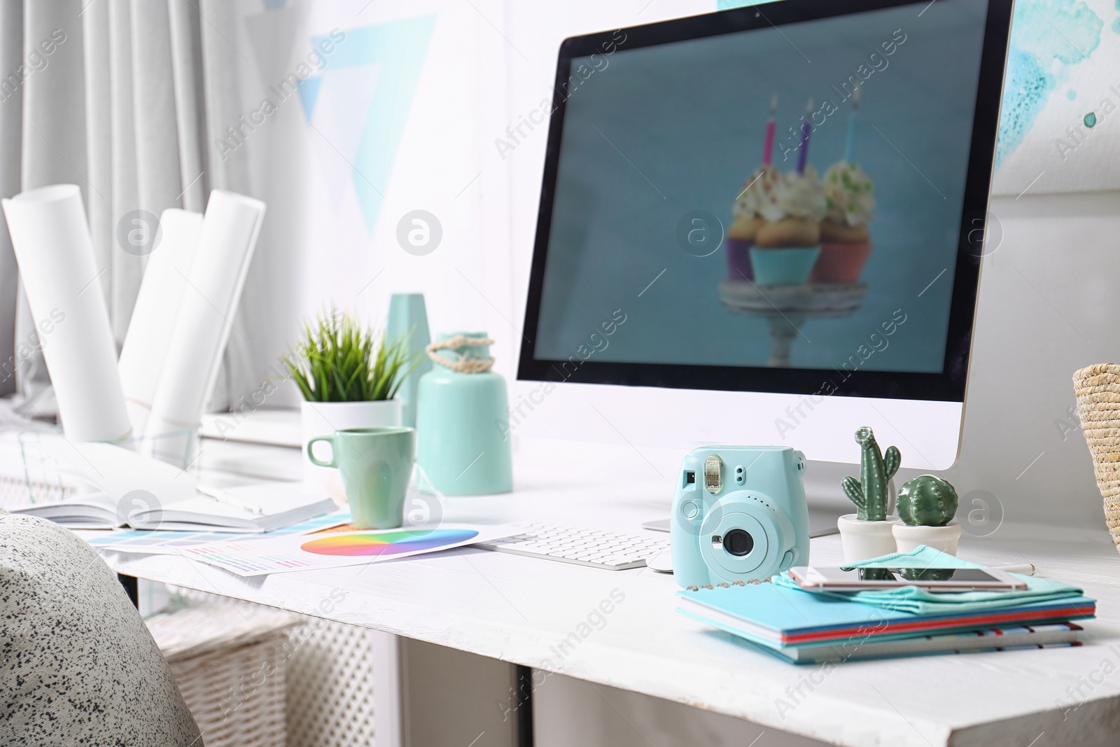 Photo of Comfortable designer's workplace with computer and digital camera in studio