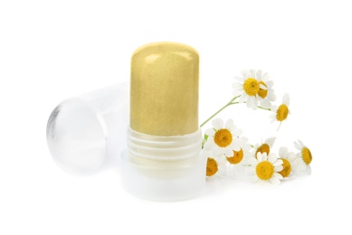 Photo of Natural crystal alum deodorant with chamomile flowers and cap on white background