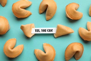 Image of Tasty fortune cookies with prediction Yes, you can! on cyan background, above view