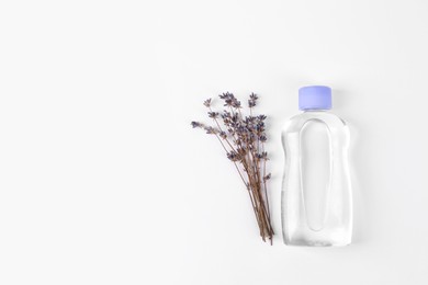 Photo of Transparent bottle with baby oil and dried lavender on white background, flat lay. Space for text