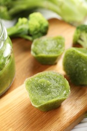 Photo of Frozen broccoli puree cubes and ingredient on cutting board