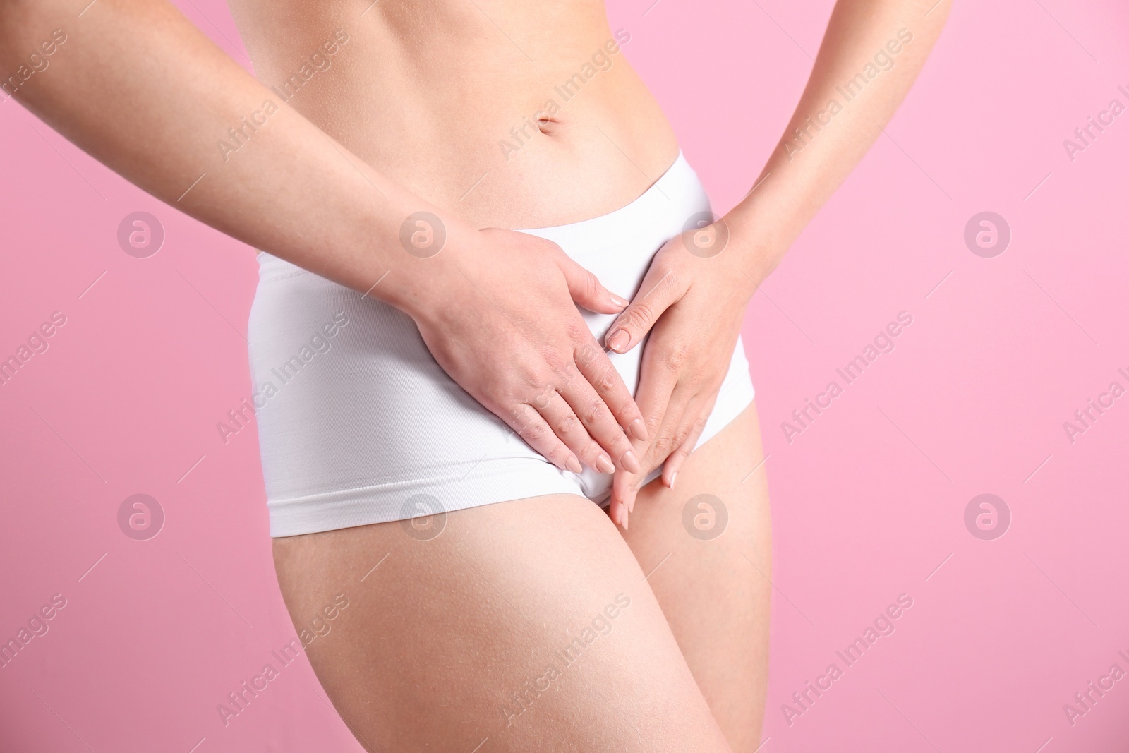 Photo of Young woman holding hands near underwear on color background. Gynecology