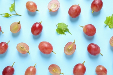 Flat lay composition with fresh ripe juicy grapes on light blue background