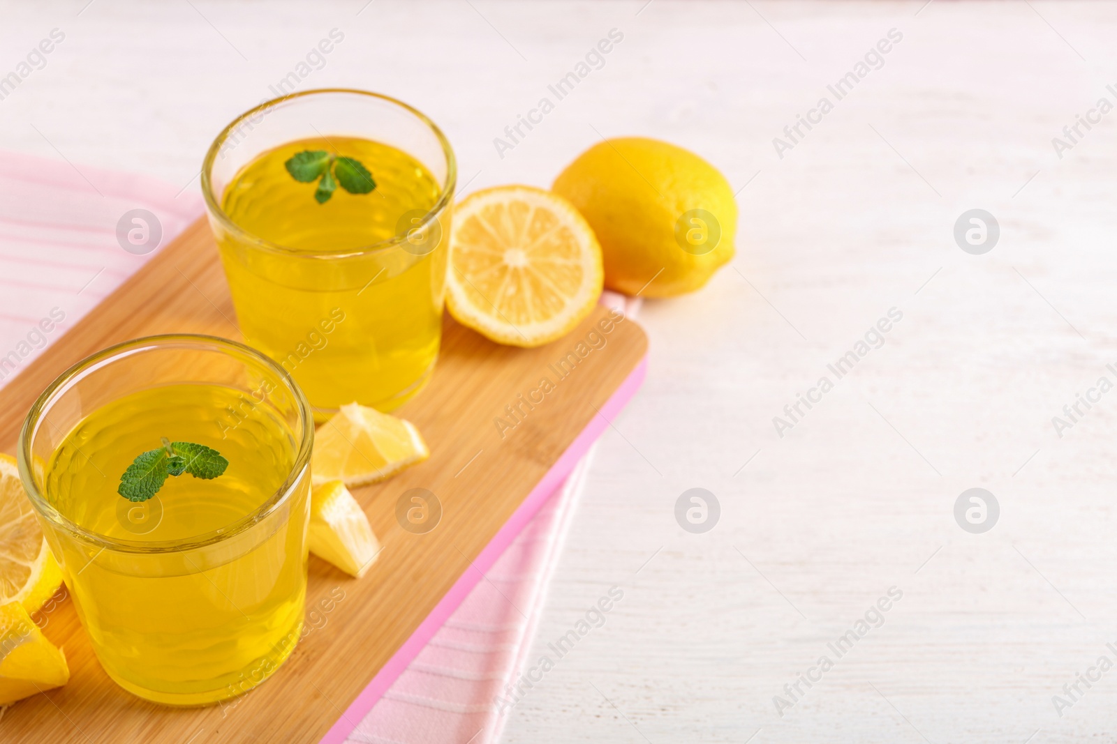 Photo of Glasses of jelly served on light wooden table. Space for text