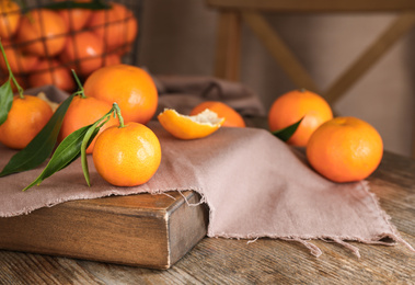 Fresh ripe tangerines with leaves on wooden table