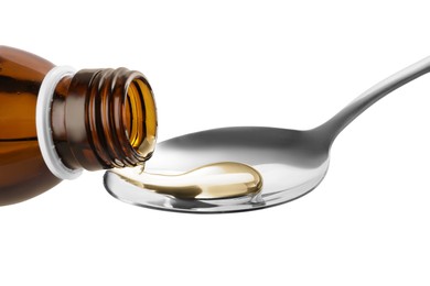 Photo of Pouring syrup into spoon from bottle isolated on white, closeup. Cough and cold medicine