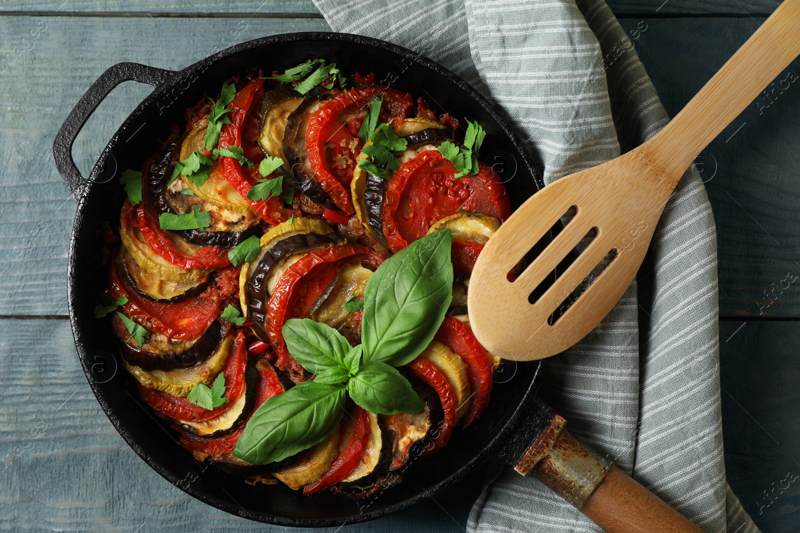 Photo of Delicious ratatouille on light blue wooden table, top view