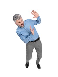 Mature businessman in stylish clothes avoiding something on white background, above view