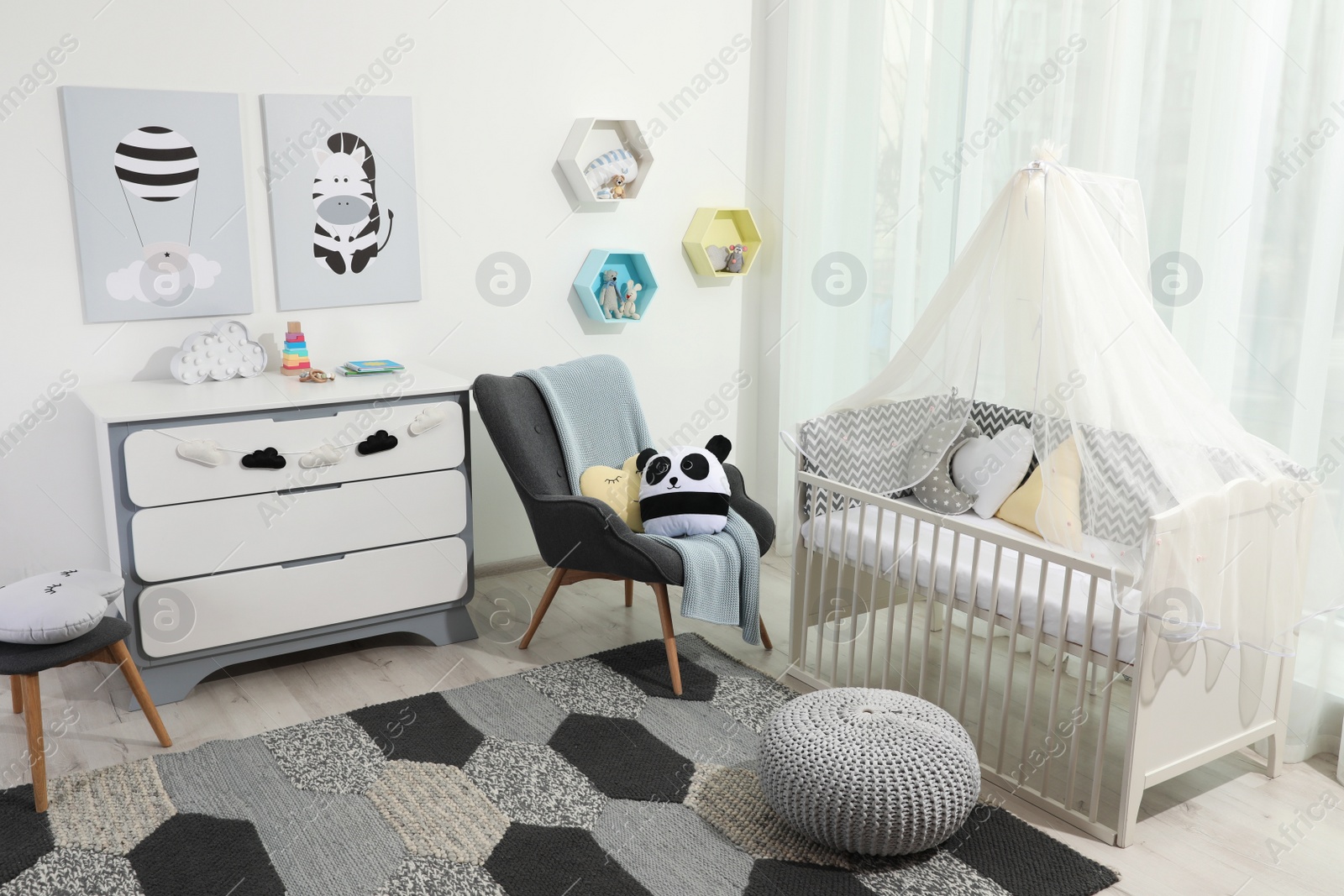 Photo of Cozy baby room with crib and other furniture. Interior design