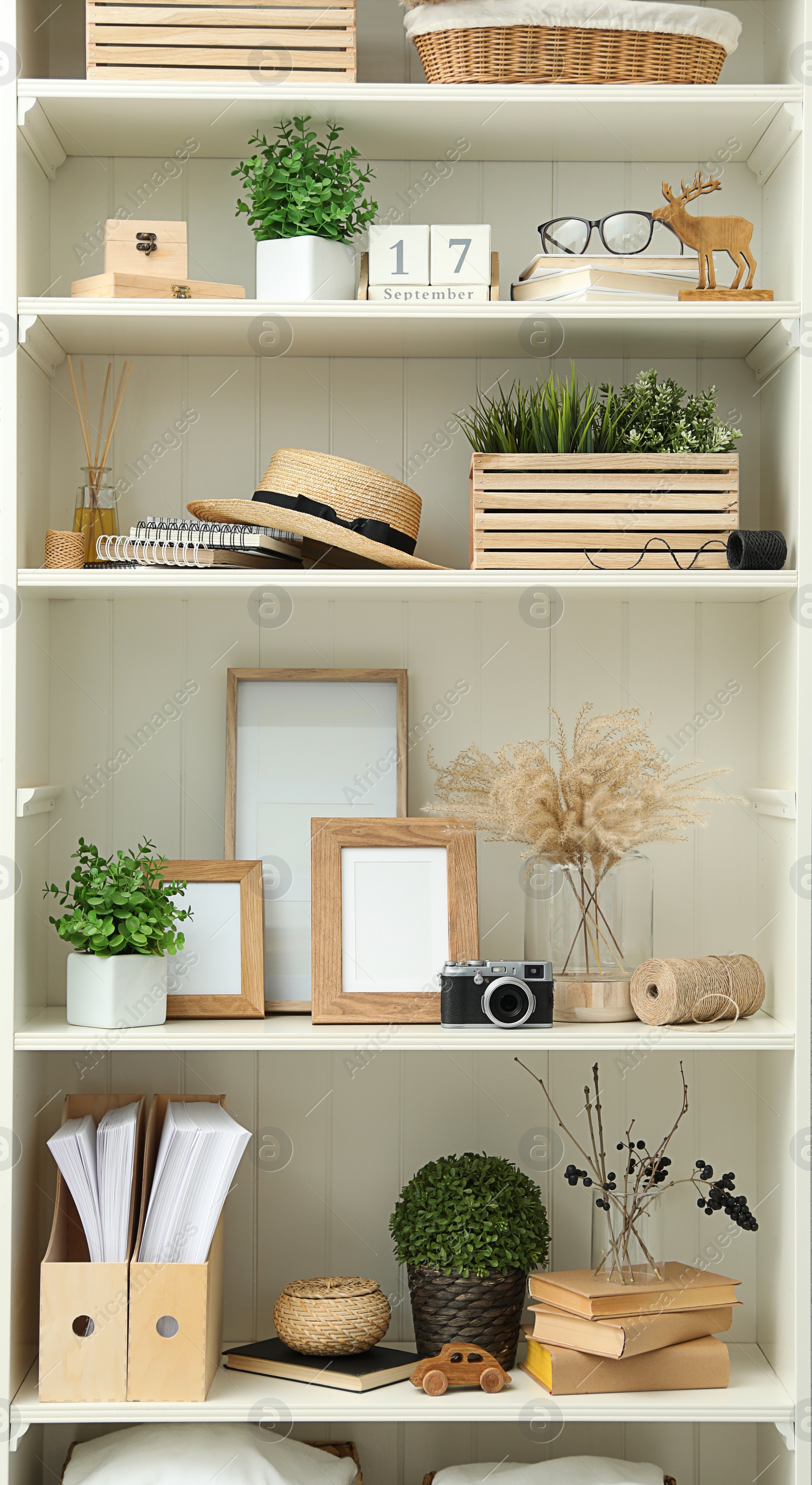 Photo of White shelving unit with different decorative elements