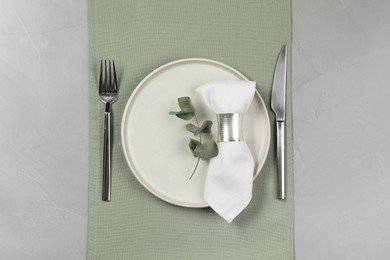 Stylish setting with elegant cutlery on grey table, top view