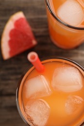 Tasty freshly made grapefruit juice and fruit on wooden table, top view