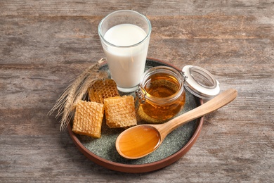 Photo of Beautiful composition with milk and honey on wooden background