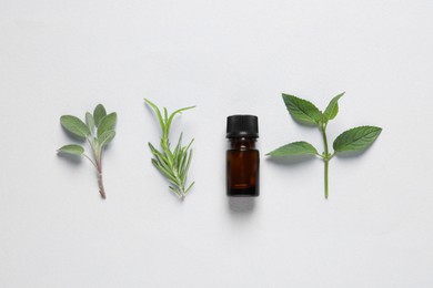 Bottle of essential oil, sage, rosemary and mint on white background, flat lay