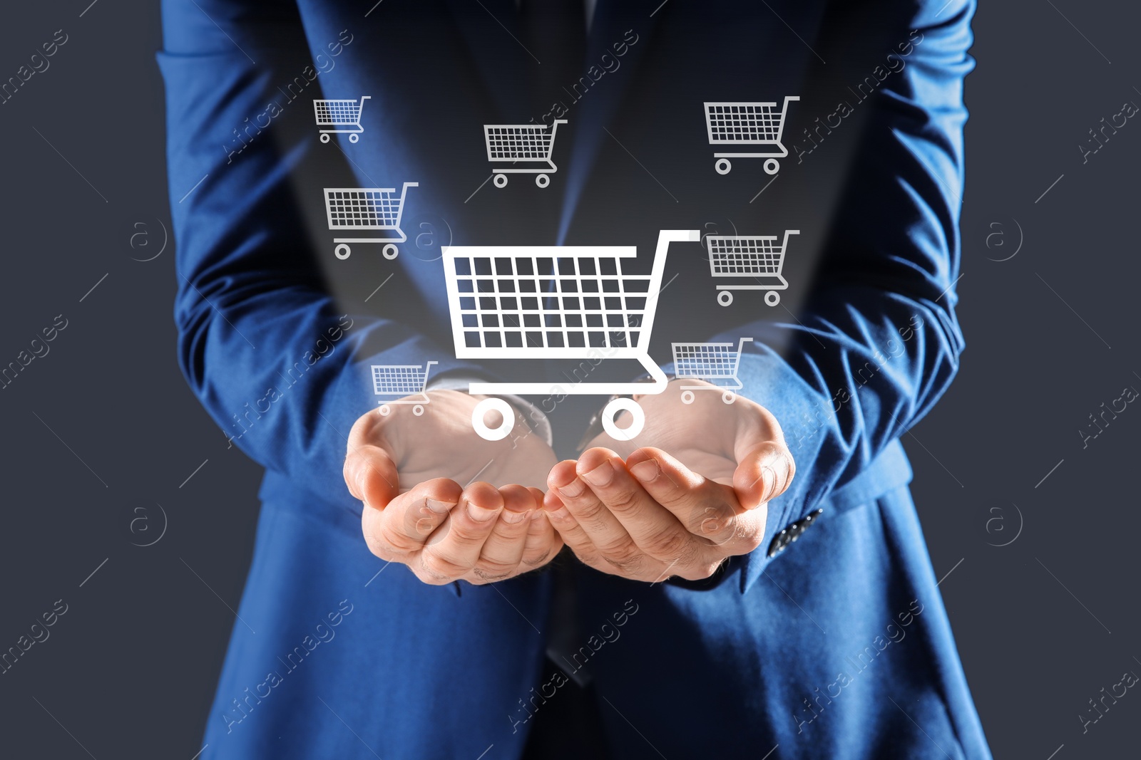 Image of Man demonstrating virtual image of shopping cart on grey background, closeup