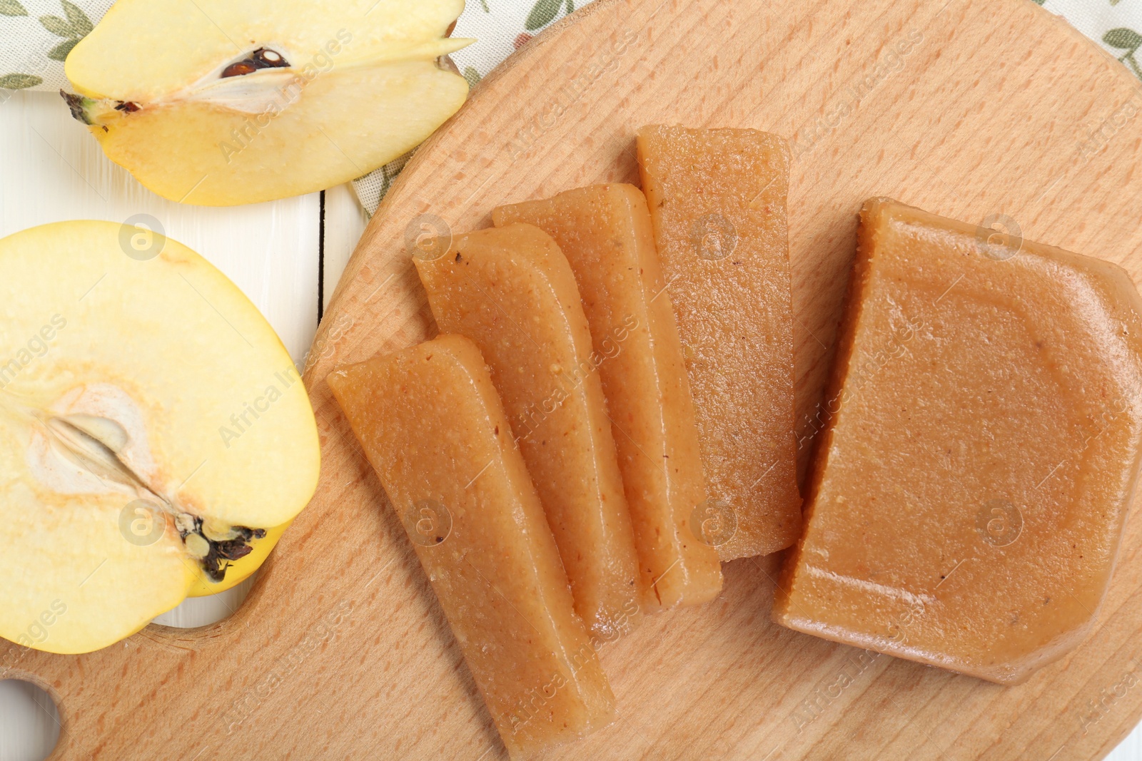 Photo of Tasty sweet quince paste and fresh fruits on white wooden table, flat lay