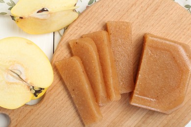 Tasty sweet quince paste and fresh fruits on white wooden table, flat lay