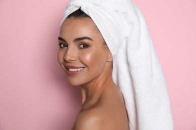 Photo of Beautiful young woman with towel on head against pink background